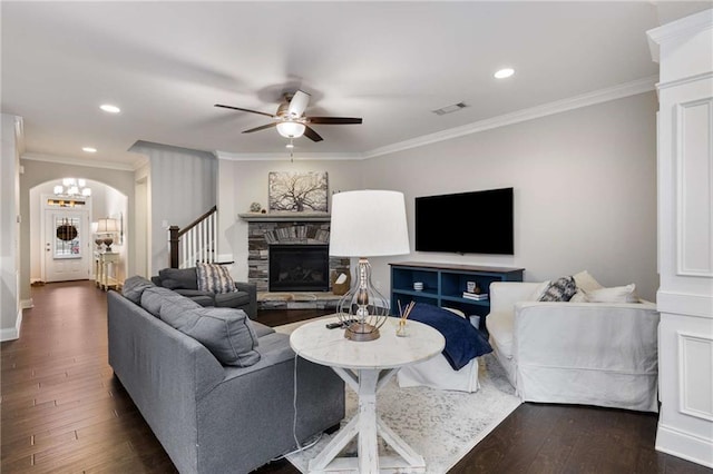 living area with dark wood-style floors, a fireplace, and crown molding