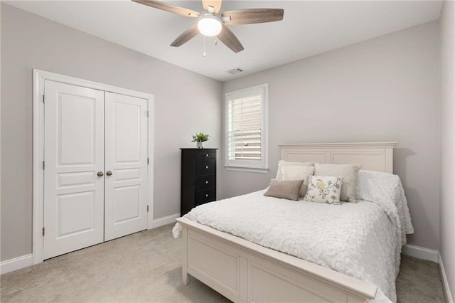 bedroom with light carpet, baseboards, visible vents, and a closet