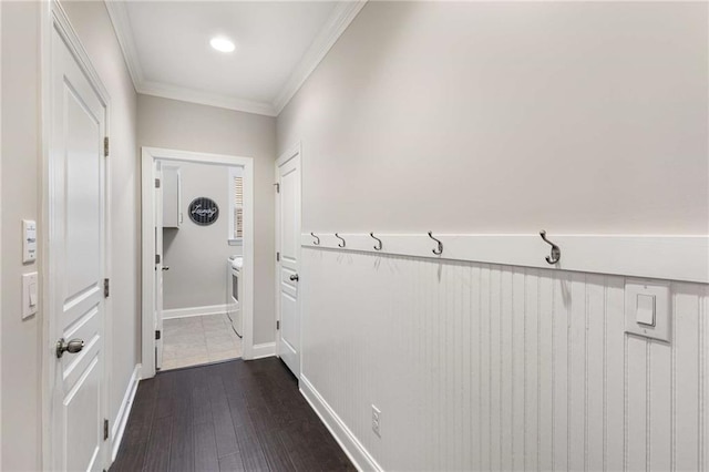 doorway featuring baseboards, dark wood-style flooring, and crown molding