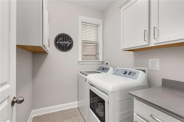 clothes washing area with cabinet space, light tile patterned floors, baseboards, and washer and dryer