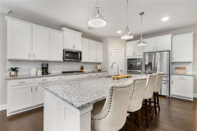 kitchen featuring appliances with stainless steel finishes, white cabinets, and a sink