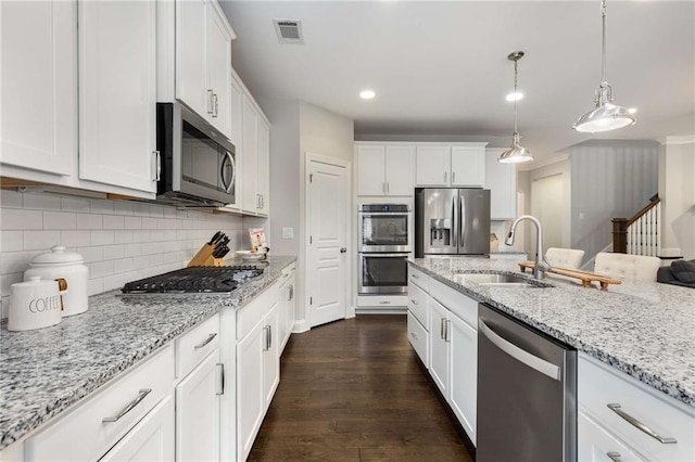 kitchen featuring a sink, visible vents, white cabinetry, appliances with stainless steel finishes, and dark wood finished floors