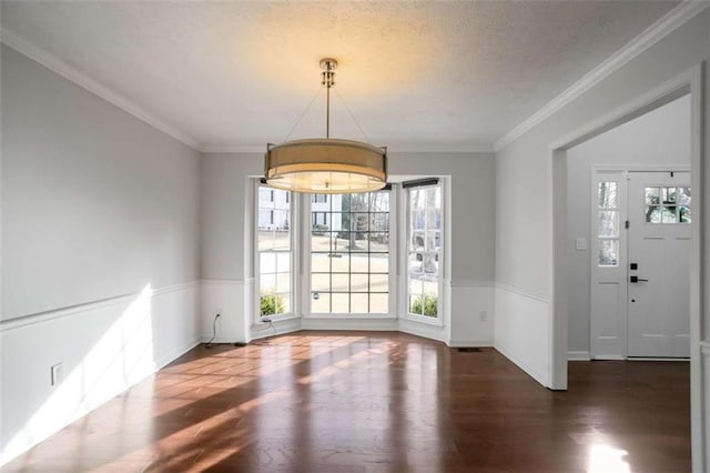 unfurnished dining area featuring dark hardwood / wood-style floors and ornamental molding