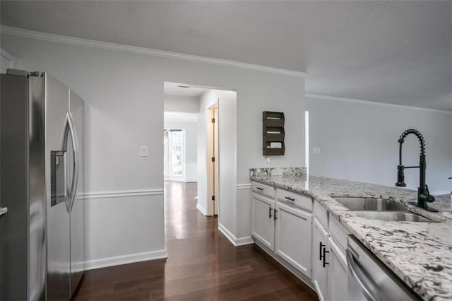 kitchen with white cabinetry, stainless steel appliances, sink, light stone counters, and crown molding