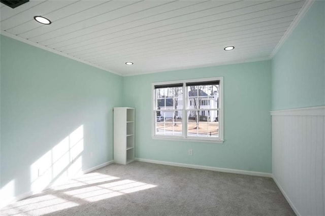 carpeted empty room with wood ceiling and crown molding