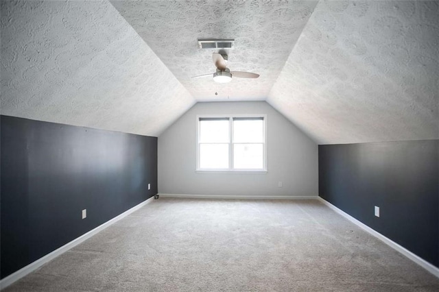 bonus room with ceiling fan, carpet, a textured ceiling, and lofted ceiling