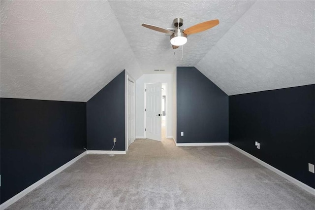 bonus room with ceiling fan, carpet flooring, a textured ceiling, and lofted ceiling