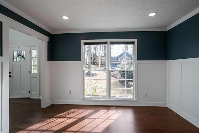 foyer entrance featuring dark hardwood / wood-style flooring, crown molding, and a textured ceiling