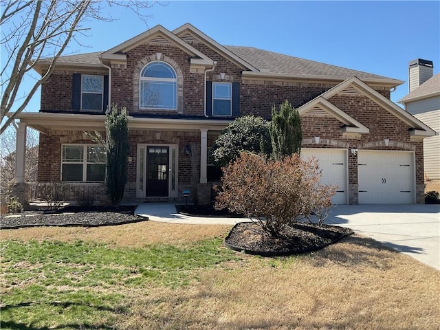 view of front facade featuring an attached garage, a front yard, concrete driveway, and brick siding