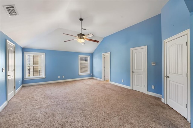 empty room featuring baseboards, visible vents, a ceiling fan, lofted ceiling, and carpet flooring