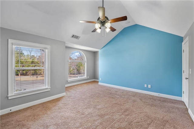 unfurnished room featuring carpet floors, a ceiling fan, visible vents, vaulted ceiling, and baseboards