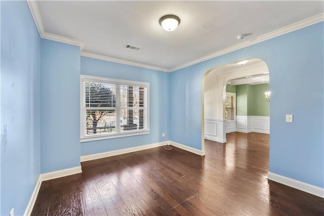 unfurnished room with ornamental molding, arched walkways, visible vents, and hardwood / wood-style flooring