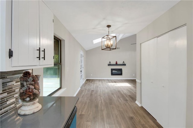 558 Newlin Ct, Lawrenceville, GA 30046 - unfurnished dining area featuring a chandelier, vaulted ceiling, and wood finished floors