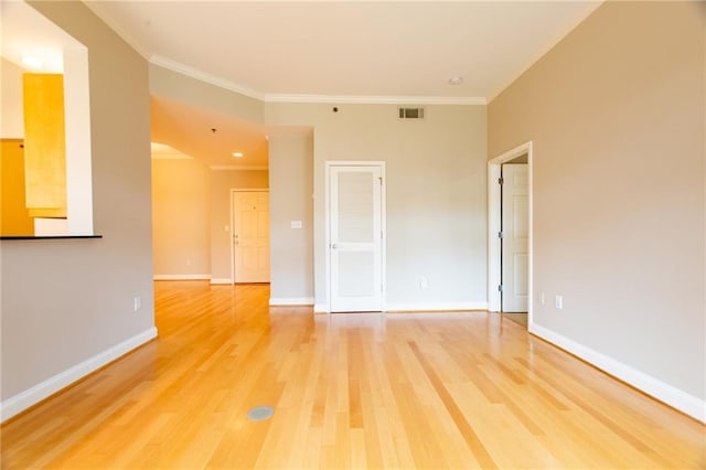 spare room featuring wood-type flooring and ornamental molding