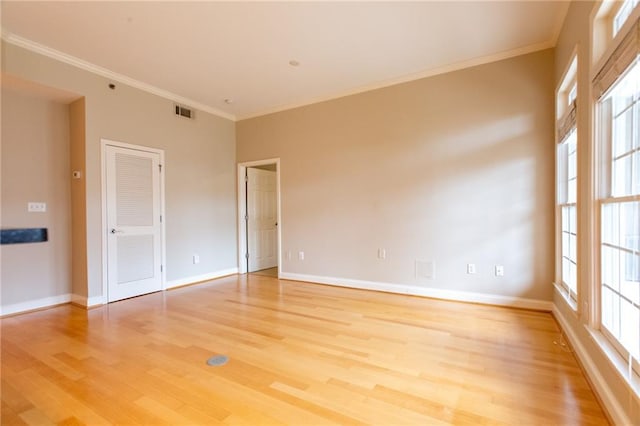 spare room featuring ornamental molding and light hardwood / wood-style flooring