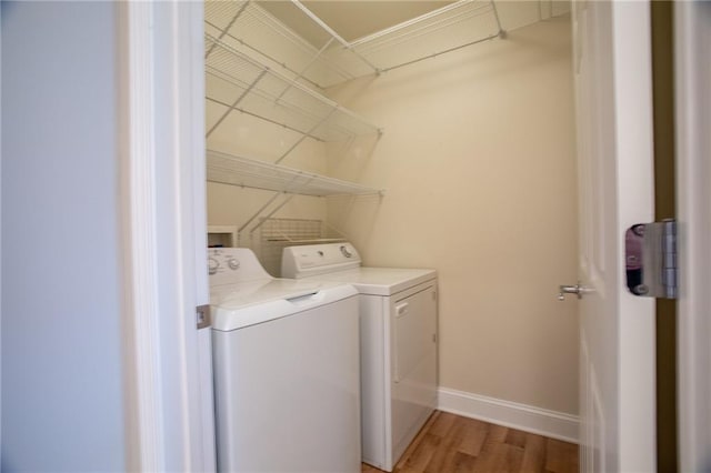 laundry room featuring washer and clothes dryer and light hardwood / wood-style flooring