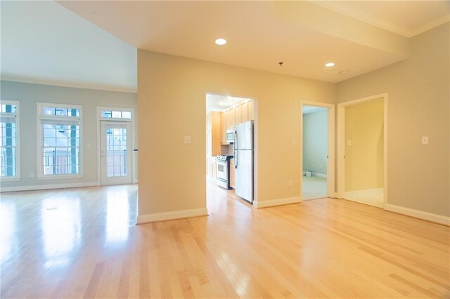 unfurnished room with light wood-type flooring and crown molding