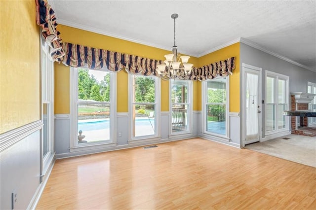 65 Millennial Ct, Lawrenceville, GA 30045 - unfurnished dining area with wood finished floors, a chandelier, a wainscoted wall, ornamental molding, and plenty of natural light