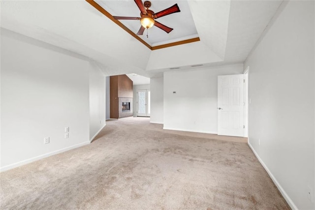 65 Millennial Ct, Lawrenceville, GA 30045 - unfurnished living room with light colored carpet, a tray ceiling, a ceiling fan, and baseboards