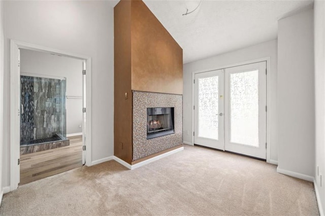 65 Millennial Ct, Lawrenceville, GA 30045 - unfurnished living room featuring carpet, a lit fireplace, french doors, and baseboards