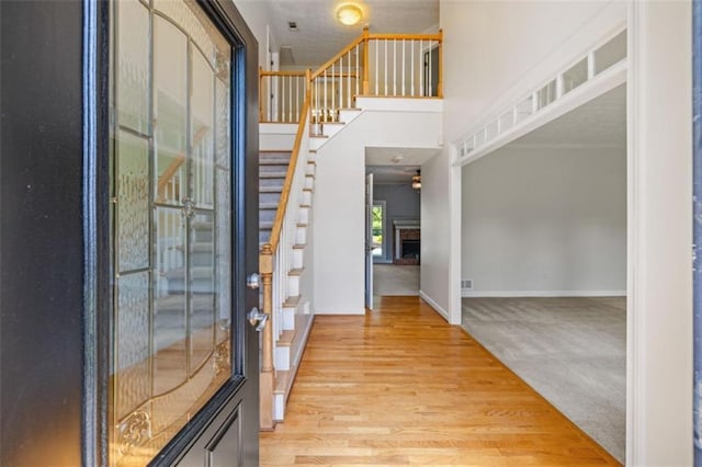 65 Millennial Ct, Lawrenceville, GA 30045 - foyer entrance with stairway, wood finished floors, a fireplace with raised hearth, and baseboards