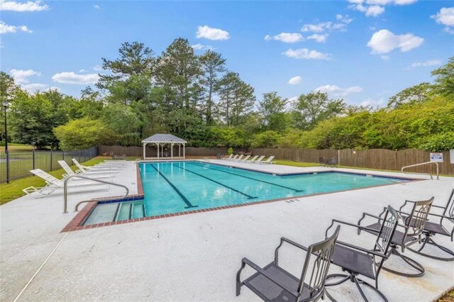 65 Millennial Ct, Lawrenceville, GA 30045 - community pool with a patio area, fence, and view of scattered trees