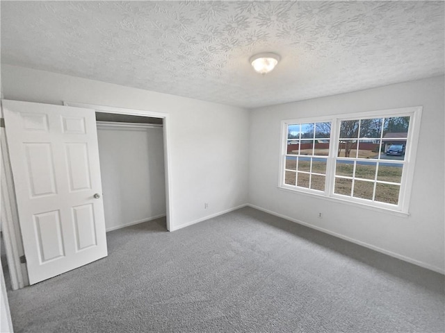 unfurnished bedroom with carpet, a textured ceiling, and a closet