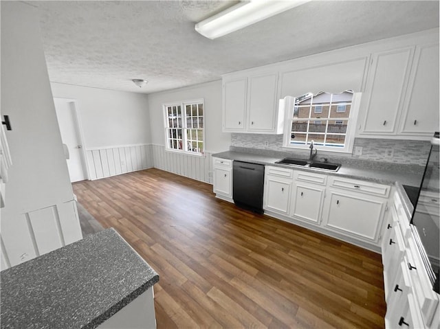 kitchen featuring sink, dark wood-type flooring, black dishwasher, white cabinets, and a textured ceiling