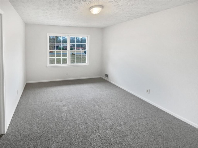 carpeted spare room featuring a textured ceiling