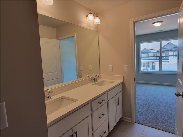 full bathroom featuring double vanity, tile patterned flooring, baseboards, and a sink