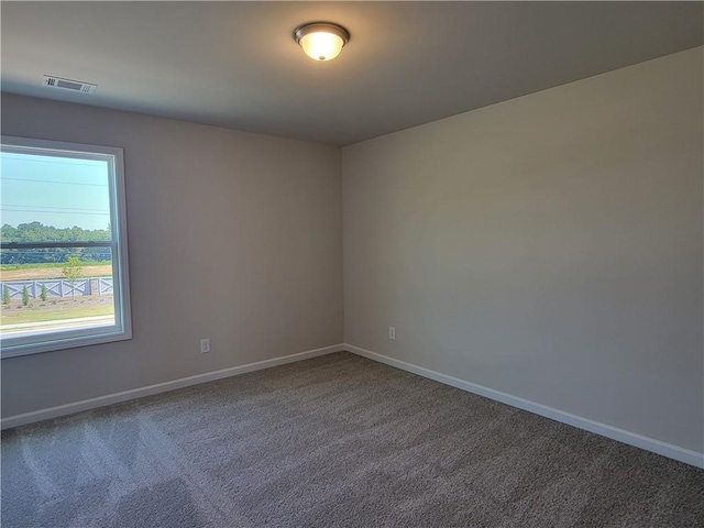 empty room featuring carpet floors, baseboards, and visible vents