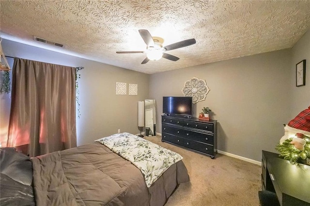 bedroom featuring ceiling fan, light carpet, and a textured ceiling