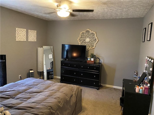 bedroom with ceiling fan, light colored carpet, and a textured ceiling