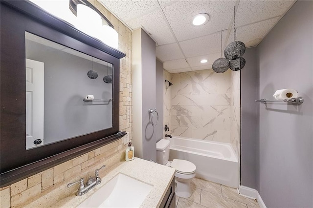 full bathroom featuring tiled shower / bath, a paneled ceiling, vanity, and toilet