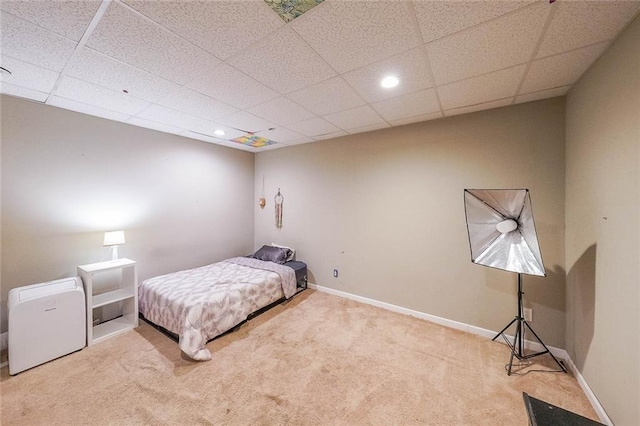 bedroom featuring a paneled ceiling and light carpet