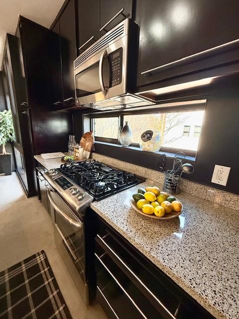 kitchen featuring appliances with stainless steel finishes and light stone counters