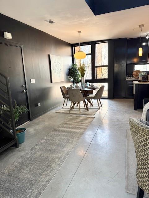 dining space with finished concrete flooring and visible vents