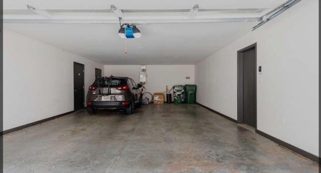 garage with a garage door opener and baseboards