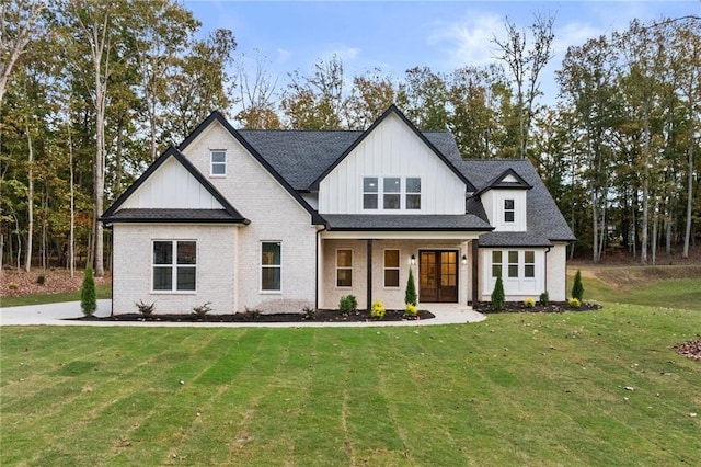 modern farmhouse style home with brick siding, roof with shingles, and a front yard