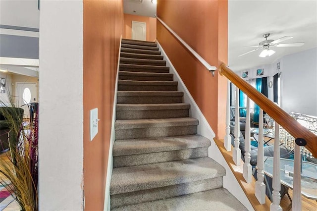 staircase featuring ceiling fan