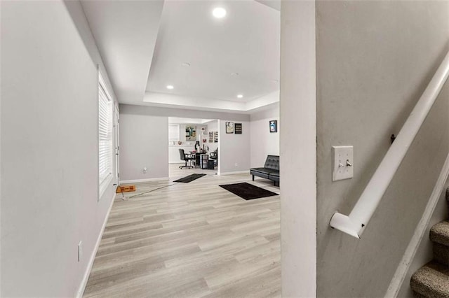 interior space featuring light hardwood / wood-style floors and a tray ceiling