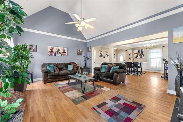 living room featuring ornate columns, crown molding, high vaulted ceiling, light wood-type flooring, and ceiling fan with notable chandelier