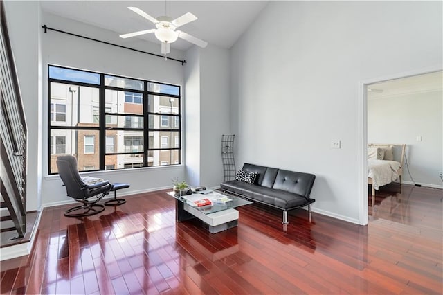 sitting room with ceiling fan, a towering ceiling, and dark hardwood / wood-style flooring