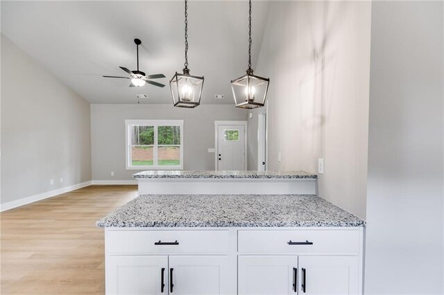 kitchen with stainless steel appliances, white cabinetry, sink, and light stone counters