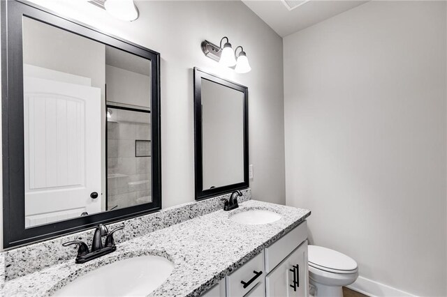 bathroom with vanity, a shower, and toilet