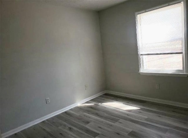 unfurnished room featuring baseboards and wood finished floors