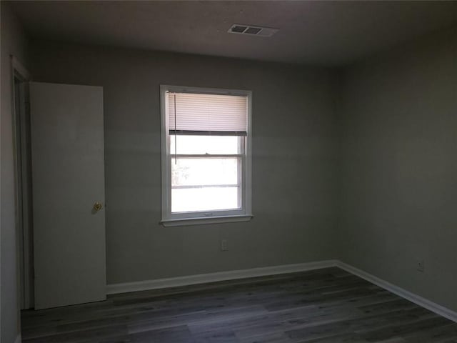 unfurnished room with visible vents, baseboards, and wood finished floors