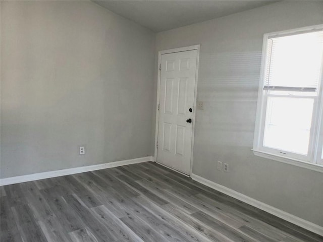 unfurnished room with baseboards and wood finished floors