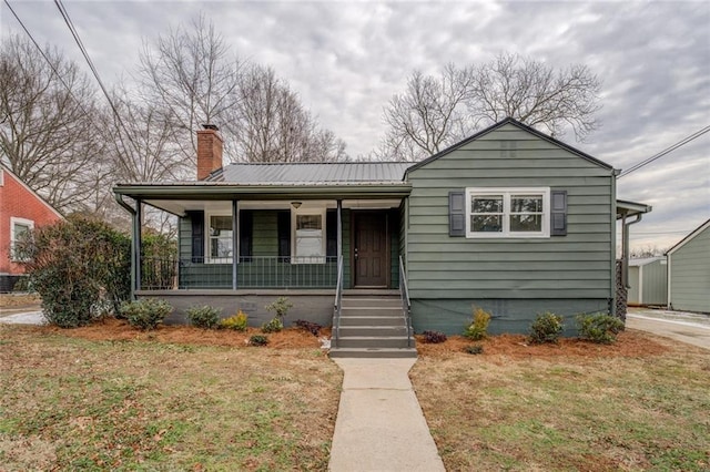 bungalow with a front lawn and covered porch