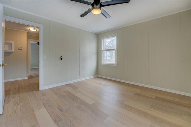 empty room featuring ceiling fan, crown molding, and light wood-type flooring